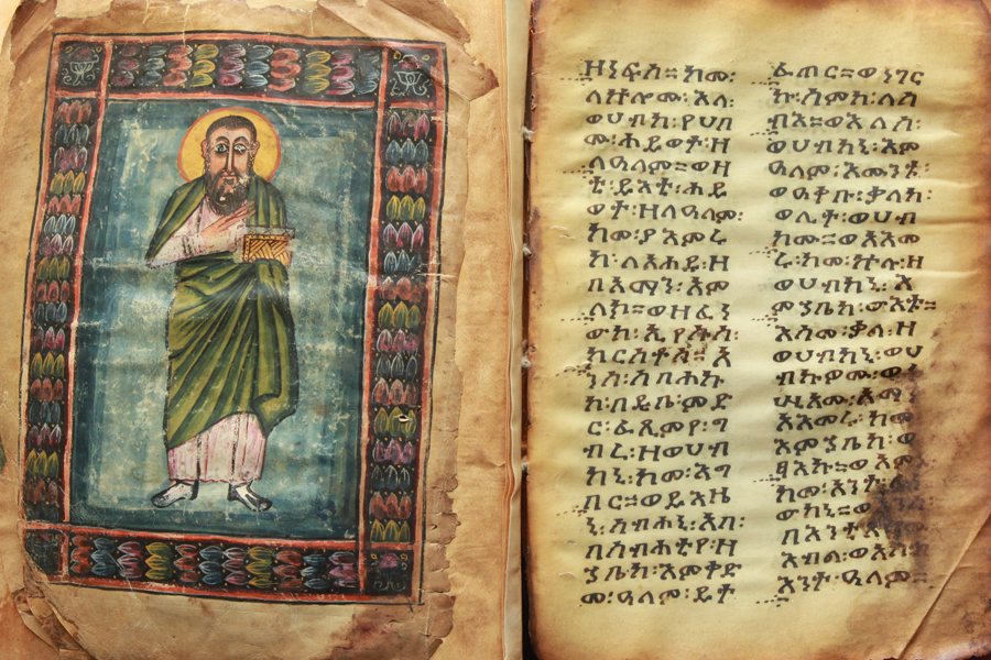 A double page from the Abba Garima gospel books after restoration: on the left a figure holding a book, on the right Geʽez text in two columns, the words separated by a two-dot divider. Not all leaves are equally old; the group also includes a gospel book from around the 14th century.