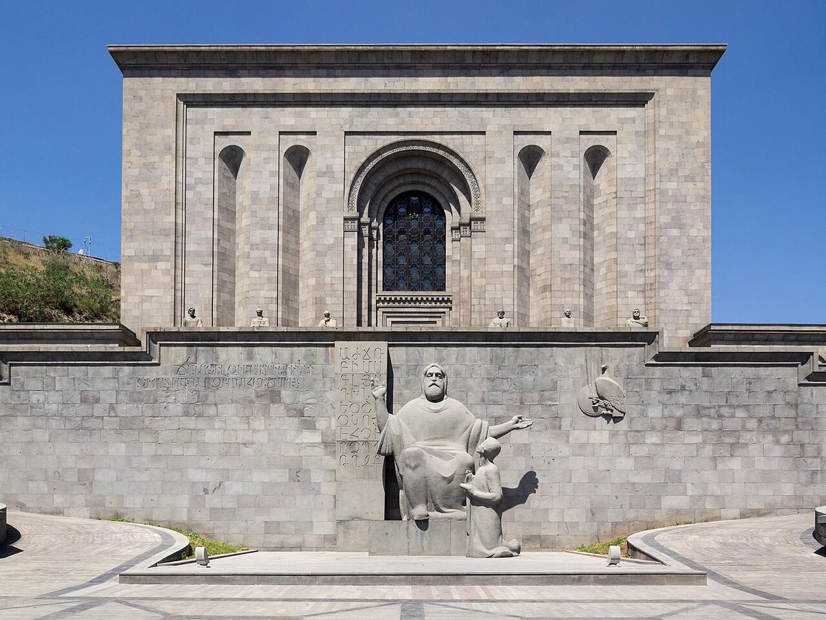 The Matenadaran in Yerevan. In front stands Ghukas Chubaryan's statue of Mesrop Mashtots with his pupil Koryun (1962, in basalt 1967), and above it statues of six medieval Armenian scholars.