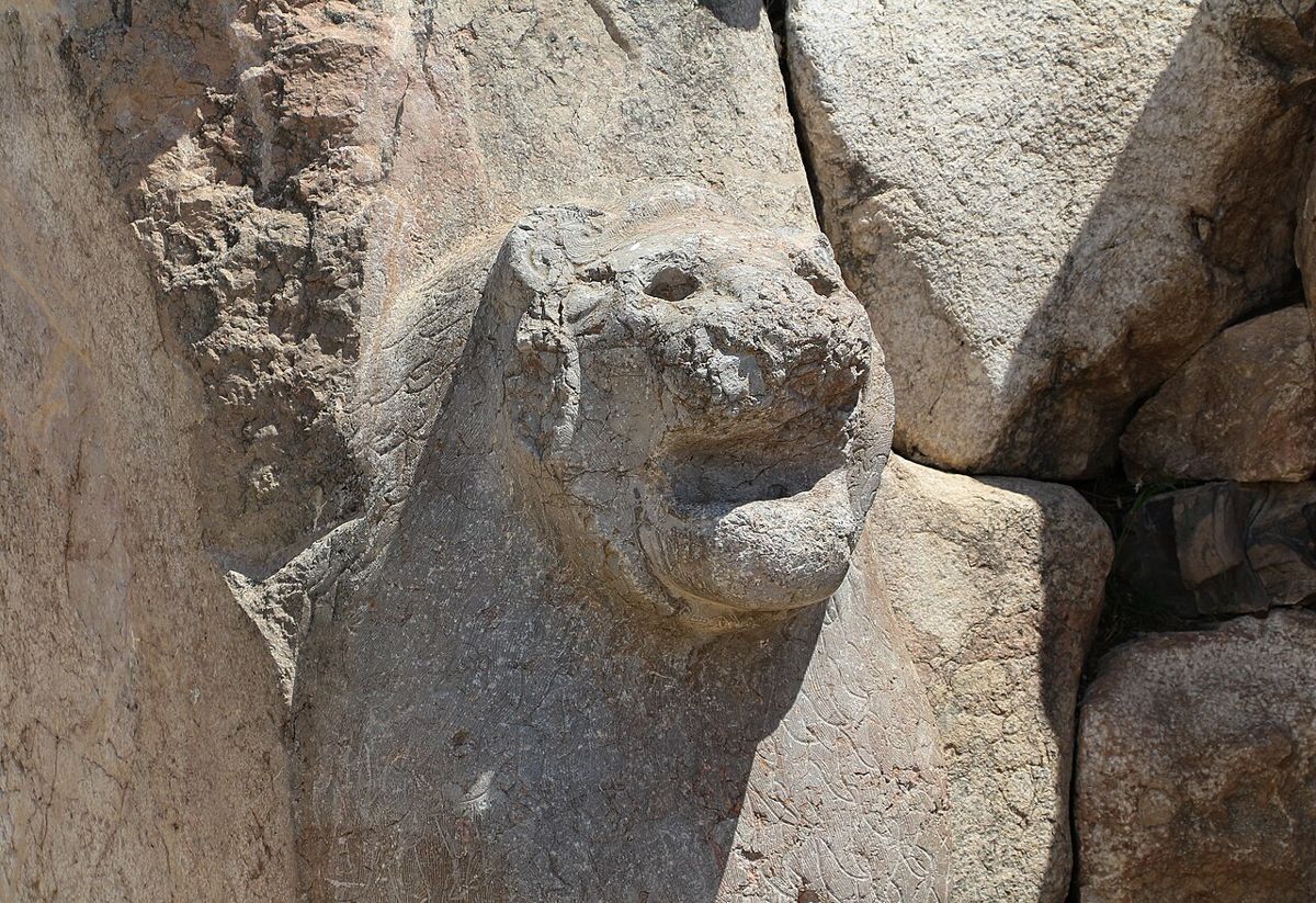 The right-hand lion of the Lion Gate. Its jaws, mane and forepaws emerge directly from the gate jamb.