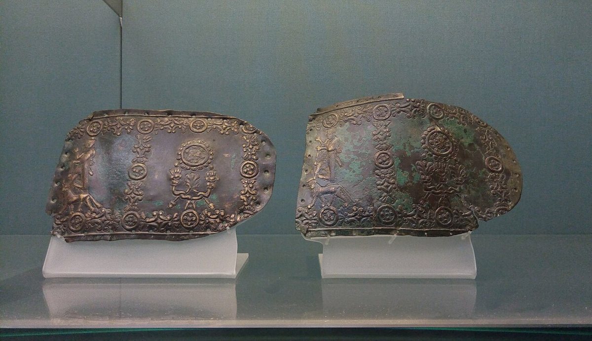 Fragments of a Urartian bronze belt, 7th century BCE, later reused as belt ends: deities standing on a bull and a lion, discs and stylised trees. British Museum, London.