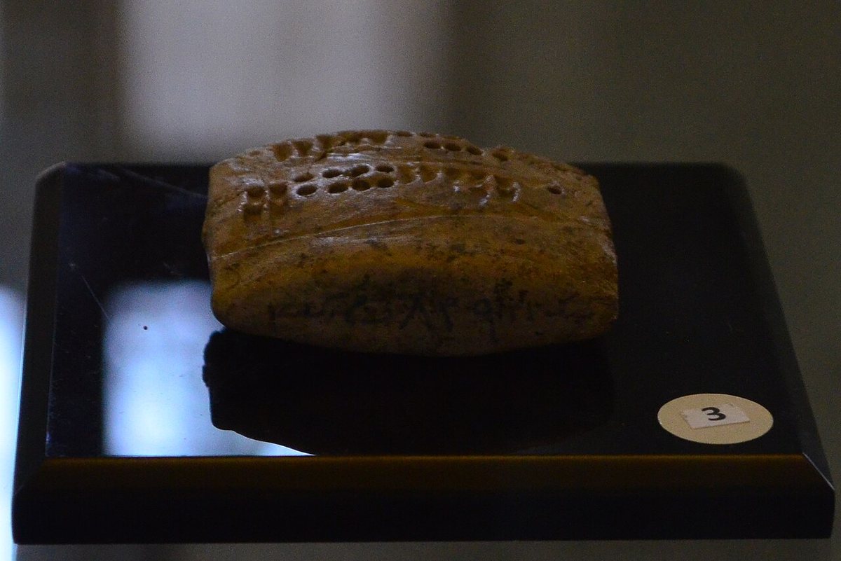 A Proto-Elamite clay tablet from Tepe Yahya in Kerman Province, c. 3000 BCE. The round and elongated impressions are numbers, set beside signs of the Proto-Elamite script. National Museum of Iran, Tehran.