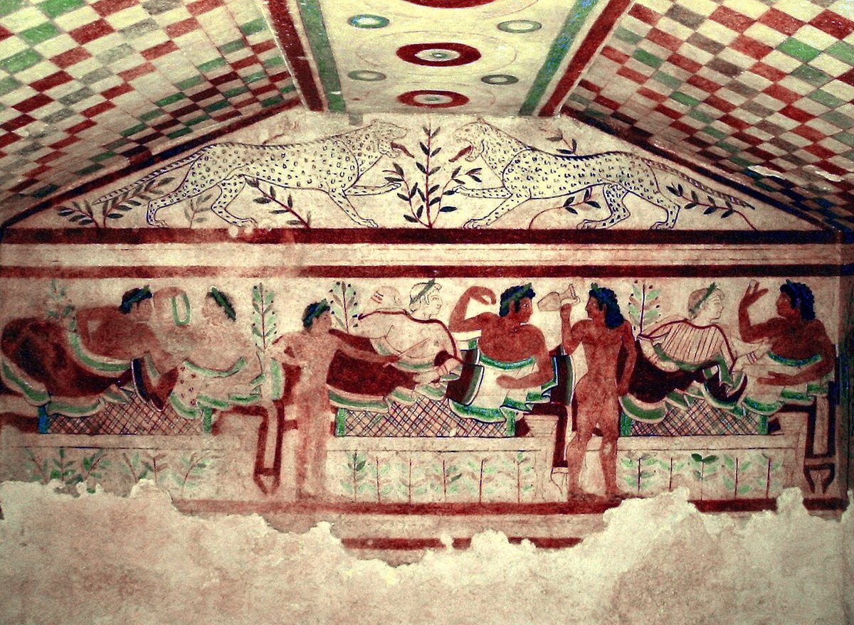 Banqueters in the wall painting of the Tomb of the Leopards in the Monterozzi necropolis at Tarquinia, c. 470–450 BCE; two leopards face each other in the gable above.