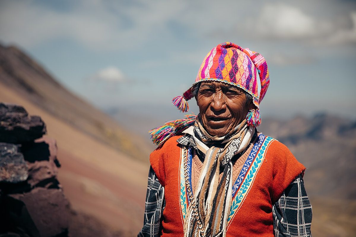 A Quechua man in traditional dress with a knitted cap at the entrance to the Red Valley in the Peruvian Andes.