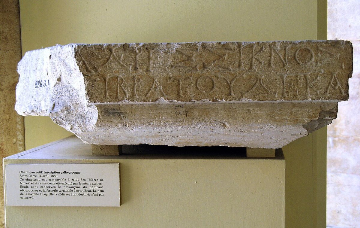 A column capital with a Gaulish dedication in the Greek alphabet, from Saint-Côme (Gard). Only the dedicator's patronymic ΑΔΡΕΣΣΙΚΝΟΣ, “son of Adressos”, and the closing formula ΒΡΑΤΟΥΔΕΚΑ[ΝΤΕΜ] survive; bratoude is usually taken to mean “in gratitude”, and the rest perhaps “a tithe”. Archaeological Museum, Nîmes.
