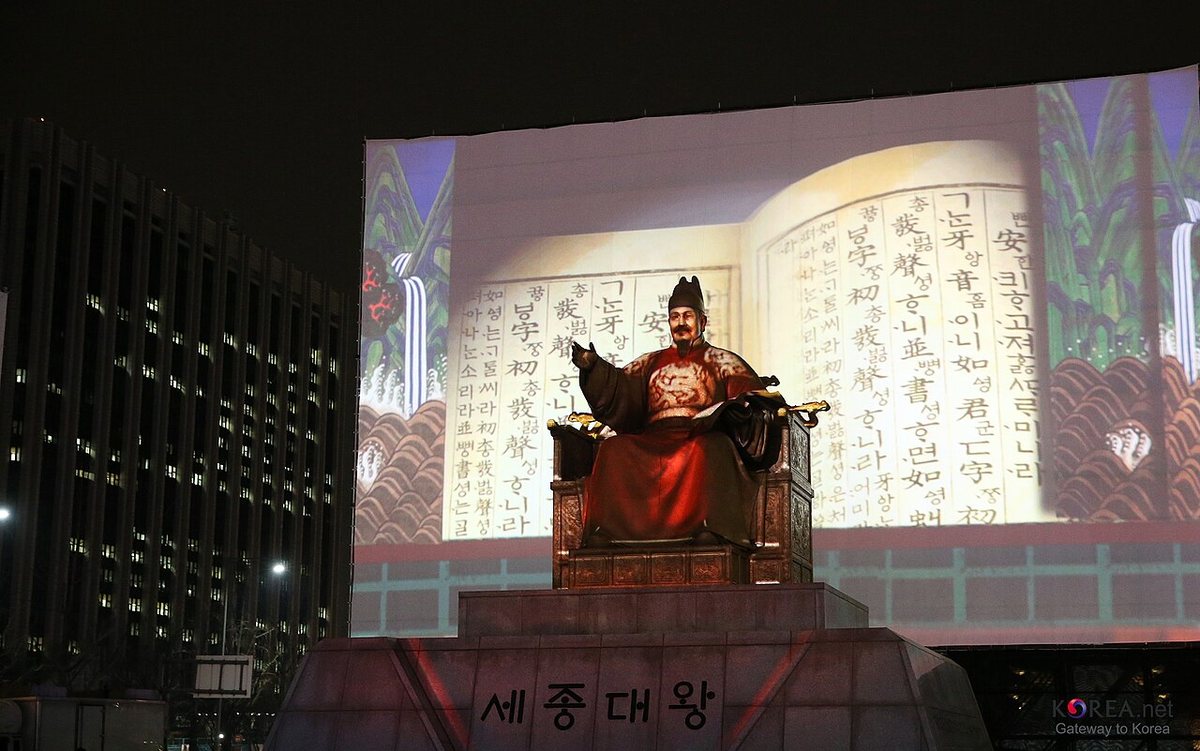 A celebration in Gwanghwamun Square, Seoul, in December 2012, when Hangul Day was restored as a public holiday. Behind the statue of King Sejong is a projection of two pages of the Korean translation of the Hunminjeongeum (Eonhae).