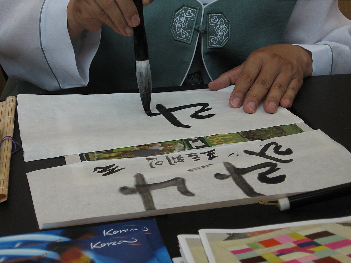 A calligrapher writing names in Hangul with a brush. Hangul calligraphy draws on the same tradition of brush and ink as the calligraphy of Chinese characters.