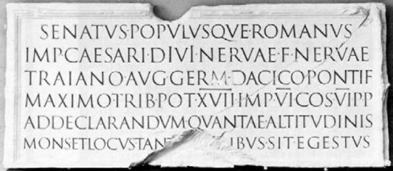 The inscription from the base of Trajan’s Column in Rome, dedicated on 12 May 113, the best-known example of Roman square capitals. Most words are separated by dots, numerals carry a bar above the letters, and the last line is damaged.