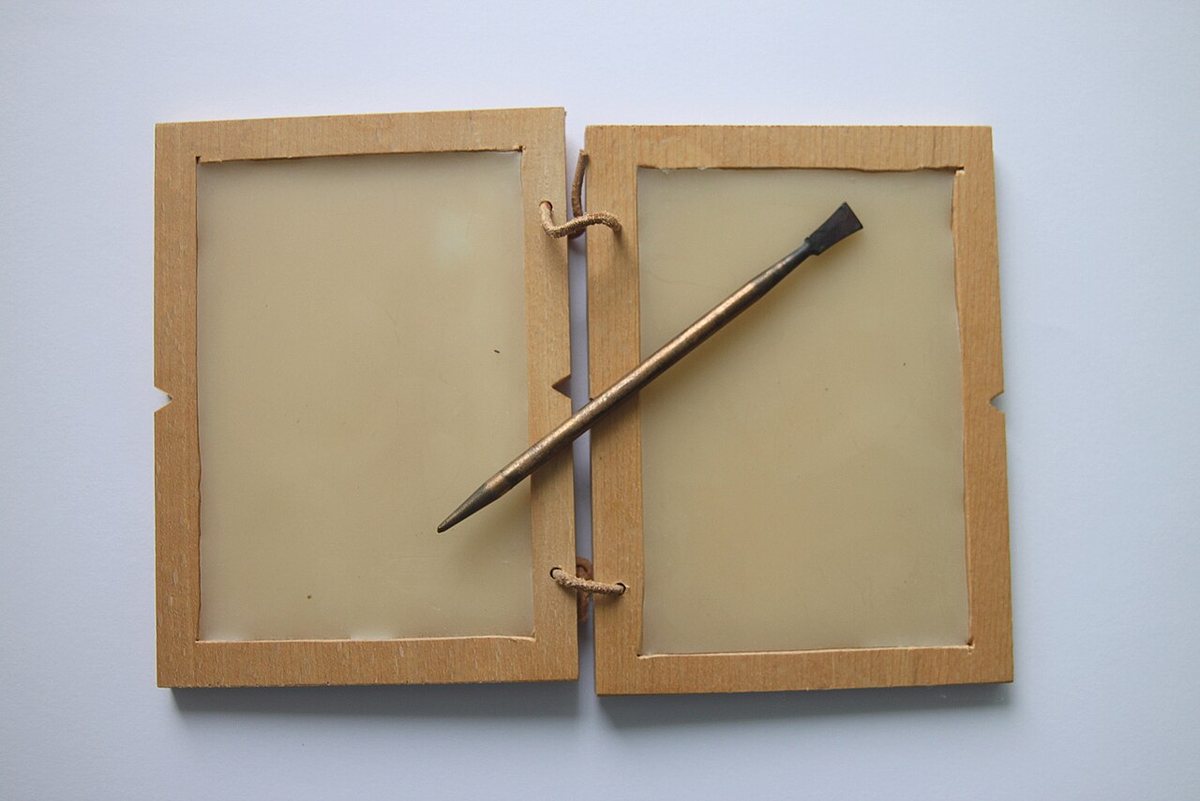 Replica of a Roman wax tablet with a stylus. The pointed end was used for writing in the wax, the flat end for smoothing it and so erasing the text.