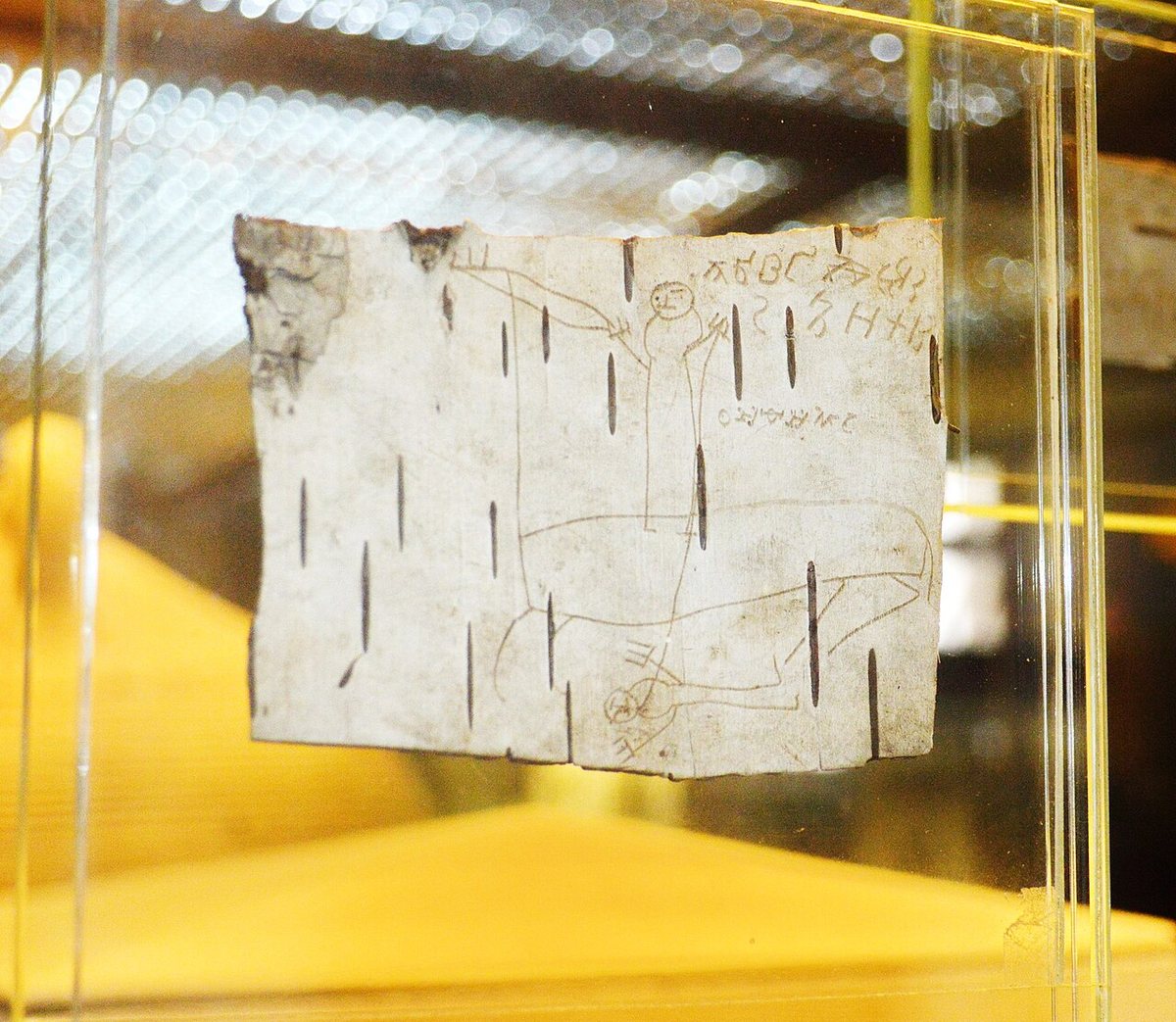 Novgorod birch-bark letter (gramota) no. 200 (1220s–1230s): a drawing of a horseman with a spear by the boy Onfim, often read as a self-portrait. Letters of the alphabet at the top right.